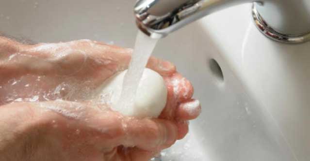 picture of a women using tap water and soap for basic wound care steps